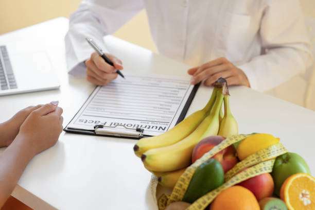 Nutritionist female doctor talking about diet plan with patient on desk