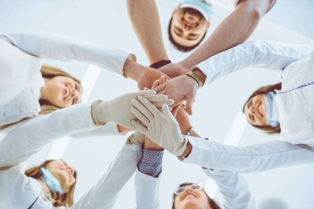 Multiethnic Medical Team Stacking Hands in Circle For Success