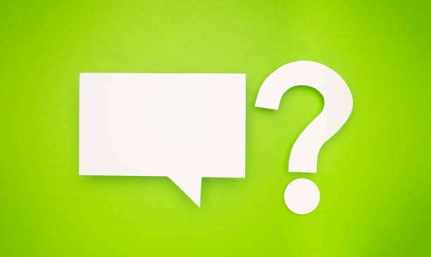 A white speech bubble and question mark symbol are on a light green background. Top view. Space for text